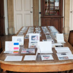 Table avec cartes postales et éditions réalisées par les élèves, Vue de l'exposition Longwy Vivra !, Mairie de Longwy Haut, 2021