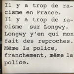 Vue de l'exposition Longwy Vivra !, Mairie de Longwy Haut, 2021. Texte imprimé ou il est écrit "Il y a trop de racisme en France. Il y a trop de racisme sur Longwy. Y'en a qui mon fait des reproches. Même la police, franchement, même la police.