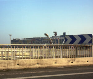 Image de l’aéroport d’Orly le jour de l’arrivée de la famille, avec le mot « Bienvenue » affiché en grand
